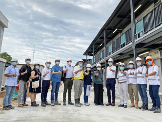 黄伟纶（右五）为兴建竹篙湾第二期检疫营舍人员打气。黄伟纶网志图片