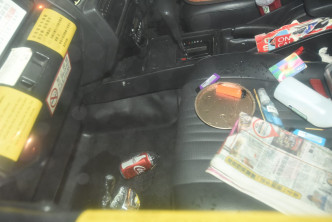 司機位旁有一罐汽水、餅罐蓋和打火機。