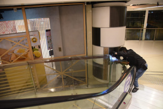 賊人跨過扶手電梯旁圍欄潛入超市內。丁志雄攝