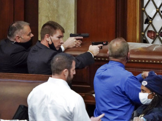 多名警员在众院议事厅内擎枪指向示威者。AP图片