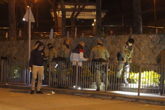 警方機動部隊人員晚上在常樂街搜尋彈頭。