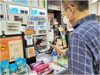 陈茂波今早出席电台直播节目前，到便利店购物，使用电子消费券支付。财政司司长网志图片