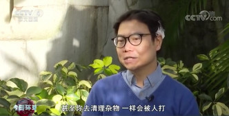 清理旺角路障被示威者用坑渠盖袭击头部的男子。央视新闻截图