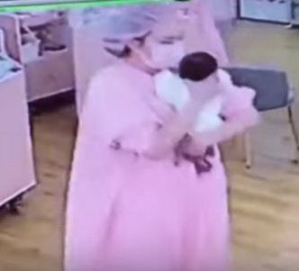 护士之后抱起一名婴儿安抚轻。网图
