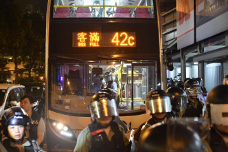 防暴警察在晚上9時半左右於九龍灣港鐵站外截停一輛巴士