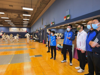 徐英伟（右三）在剑击馆内听取剑击总教练郑兆康（右四）讲解训练的情况。