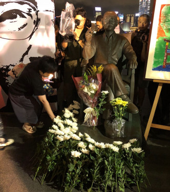 市民把鲜花放到刘晓波铜像前。