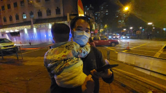 手抱婴儿的居民胡先生称担心疫情，会配合政府措施