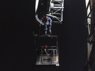 维修技术人员在高空工作，正爬上工程车。