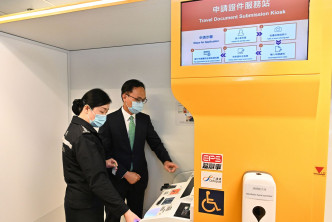 聂德权（右）了解使用申请证件服务站申请香港特别行政区护照的步骤。