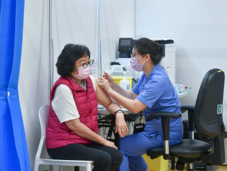 前民政事务局常任秘书长李丽娟（左）接种疫苗。