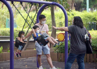 家长带小朋友到公园玩耍。