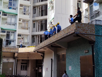 女子倒斃平台，消防協助將死者遺體運到地面。 梁國峰攝