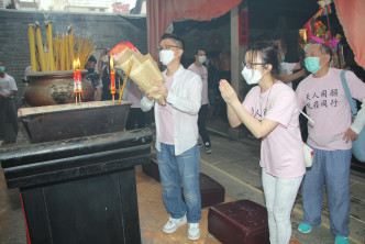 李博士手持寶碟與太太劉倩婷一起進行拜祭儀式。