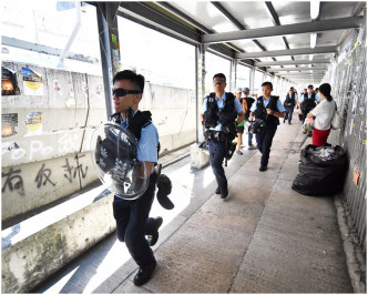 帶備盾牌和頭盔的警員九龍灣「連儂牆」呼籲不要在場逗留。