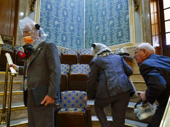 警方指有示威者进入圆形大厅，让议事厅内的众议员随时准备拿出座位下的防毒面具戴上。AP图片