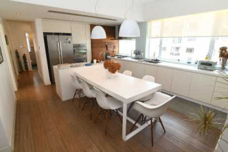 飯廳布置以白色為主，與開放式廚房空間相連。