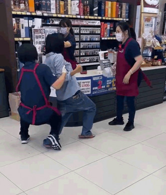 大媽圖硬闖超市另一名女店員上前合力將她制服。影片截圖