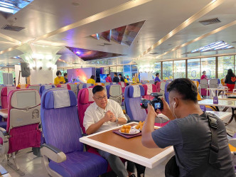 胡慧冲喺一间航空公司总部嘅员工餐厅，品尝经济客舱飞机餐。