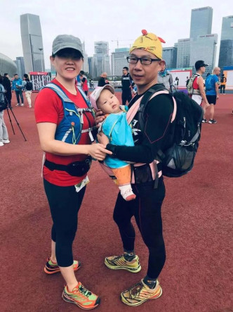女嬰被抱住跑馬拉松。網上圖片