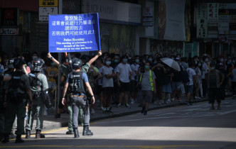 警方举蓝旗警告游行人士。