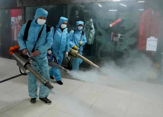 工作人员在商城走廊内喷药消毒为复工作准备。新华社