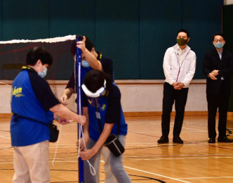 徐英伟（右二）及刘明光（右一）视察职员在球场装置羽毛球运动的设施。 政府图片