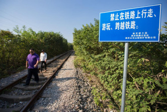遊客無視警告在鐵路上行走。網圖