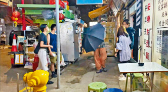 姜涛甫完成拍摄，便有工作人员在外撑伞等候。