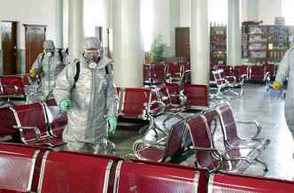 在朝鲜，穿著防护服的工人对设施进行消毒。AP资料图片