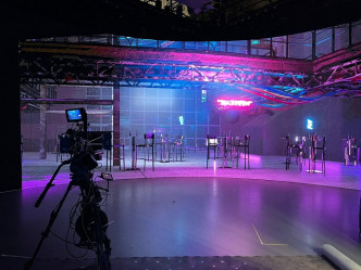 團隊利用 XR拍攝技 術，先設計整個虛擬場景 ，設定特效及燈光效果，輸出 至 LED背景板，演員站在片場，猶如置身在真實的 拍攝 場 景 中。