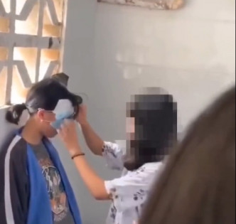 同学以口罩遮住受害女生的眼睛。网图