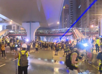 有示威者向警察方向照射強烈紫色光束。有綫新聞
