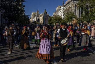 西班牙民眾穿着傳統服裝上街表演。 （美聯社）