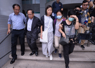林子健代表律师及家属离开法院。左二为何俊仁。