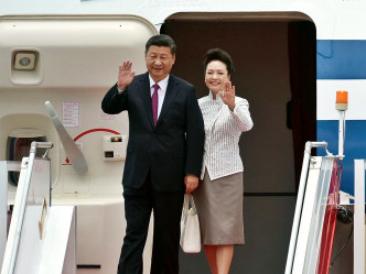 国家主席习近平结上暗红色呔，夫人彭丽媛则穿着银白色衣服，抵达香港。