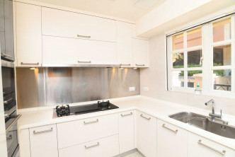 厨房设备齐全，如白色厨柜及通风大窗等。