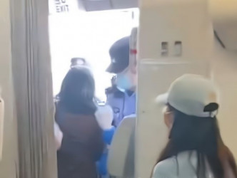 女子被押离机舱。网图