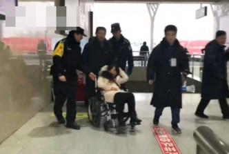 職員用輪椅將受傷女子推出車站再枱上救護車。