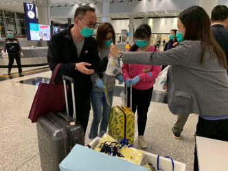 港人到达香港机场后，入境处职员为他们派发由航空公司提供的食物包。读者提供