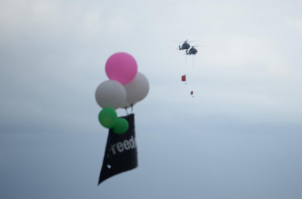 数个挂有黑底白字「#FreedomHK」横额的气球升空抗议。