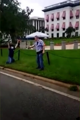 白人拔出手槍指向示威者。網上影片截圖