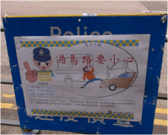 警員在路邊豎立過馬路要小心的宣傳牌。林思明攝