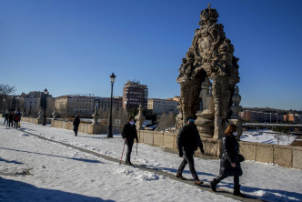 人们在西班牙马德里托莱多桥的雪地上行走。AP图片
