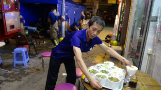 店主李先生为救援人员烹煮鱼蛋粉。黄文威摄