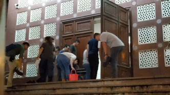 警方攜水桶進入寺內。