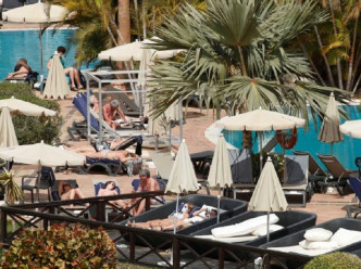 酒店内不少住客戴著口罩在泳池游泳。网图