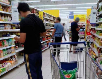 男士拿着手中的购物清单努力地在超市层寻宝。fb