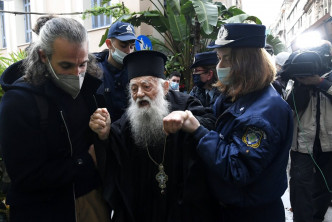 年长的东正教教士被警察拉走。美联社图片