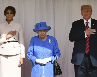 特朗普夫妇一左一右站在女皇两边令站在中间的英女皇明显矮了一截。AP